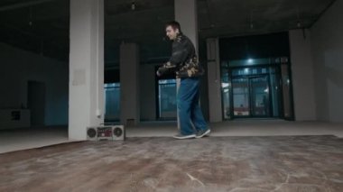 Sokak kıyafetleri içinde break dans yapan ve el ele tutuşarak yaratıcılığını ve mükemmel ayak hareketlerini gösteren yetenekli beyaz çocuk B-boy 'un zemin seviyesi.