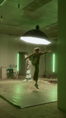 Kafkas jenerasyonu Z B-boy 'un dikey geniş yavaşlığı zarif break dans hareketleri yapıyor, diğer arkadaşlarla içeride pratik yapıyor.