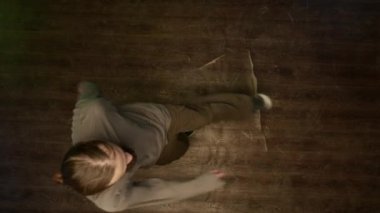 Sokak kıyafetleri içinde dans pistinde enerji ve bireysellik dolu yaratıcı break dans yapan beyaz bir gencin en iyi görüntüsü.