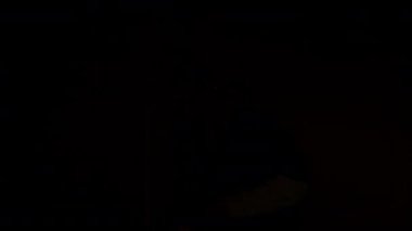 Şehir kıyafetleri içindeki beyaz çocuk el kamerasıyla diğer adamların önünde ışık altında yaratıcı hareketler sergiliyor.