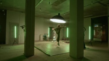 Kafkas jenerasyonu Z B-boy 'un geniş yavaşlığı zarif break dans hareketleri yapıyor, diğer arkadaşlarla içeride pratik yapıyor.