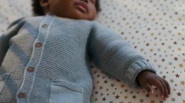 Yakın çekim, rahat ve sakin Afrikalı Amerikalı çocuk, huzur içinde uyur yıldız desenli çarşafların üzerinde