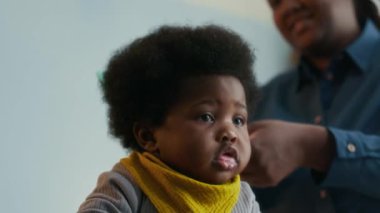 Annesi saçını tararken Afrika kökenli Amerikalı çocuğun yakın plan fotoğrafı.