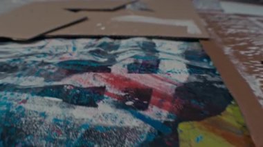 Yüksek açı. Hiçbir insan üzerinde beyaz izler olan kartondan yapılmış farklı renkler içeren soyut resim yüzeyini çekmez.