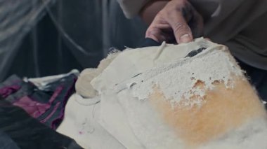 El yapımı spatula kullanarak köpük detaylarına beyaz sıvı boya sürerken tanımlanamayan el işi bir fotoğraf.