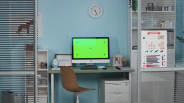 Çağdaş veteriner kliniğinde yeşil ekran masası, veteriner sertifikası çerçeveli köpek fotoğrafı ve duvarlarda asılı tıbbi afişleri olan insanlar yok.