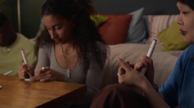 Üç farklı arkadaş gurubu yurt odalarında tahmin oyunu oynamaya hazırlanıyor, kağıtlara yazı yazıyorlar.