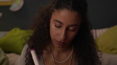 Neşeli melez kız kağıda kelime yazıyor ve arkadaşlarına oyun oynamaya hazır olup olmadıklarını soruyor.