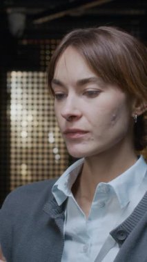 Dijital tabletle sunucu odasında duran ve sonra kameraya bakıp gülümseyen genç, kendine güvenen beyaz kadın bilişim uzmanının dikey yavaş portresi.