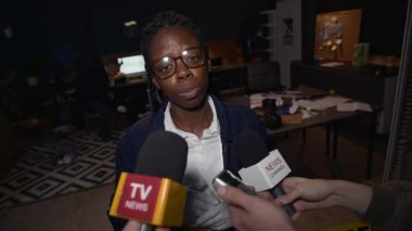 Genç, kendine güvenen siyahi kadın polis memurunun suç davası hakkında yorum yaparken orta boy fotoğrafı, ofisteki suç mahallinde onunla röportaj yapan basının sorularını yanıtlıyor.