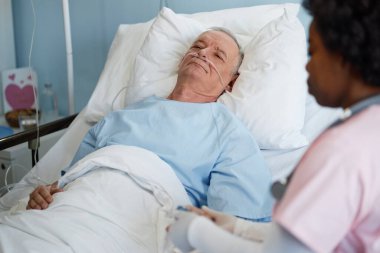 Hastane yatağında yatan yaşlı bir adam hastane görevlisi ile tıbbi detayları tartışıyor, empati paylaşıyor ve hastaların sağlığını ve kritik derecede iyileştiriyor.