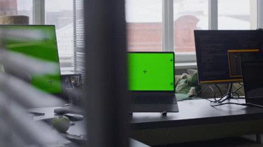 Gündüz vakti boş ofis masasında yeşil ekran bilgisayarlardan ve dizüstülerden çekilen el bilgisayarı yok.
