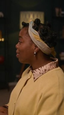 Sevdiklerinin el ele tutuşan mutlu zenci kadının dikey karesi. Şenlikli akşam yemeğinden önce birlikte dua ediyorlar. Evde yemek masasında oturuyorlar.