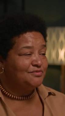 Yemekten önce dua ederken, evde aile kutlamaları sırasında yemek masasında birlikte otururken, Black Nine 'nin yetişkin çocuklarla el ele tutuşurken çekilmiş dikey bir fotoğrafı.