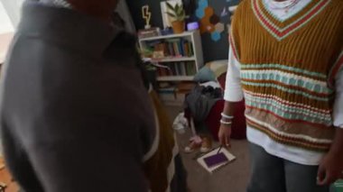 Afroamerikan ergen erkek ve kızın el kamerasıyla çekilmiş sıcak bir odada kavga ederken, gülerken ve evde birlikte vakit geçirirken.