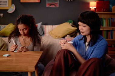 Arkadaşlar sıcak ışıklandırmalı, minderler ve dekorlarla çevrili rahat oturma odasında ders çalışmaya ve notlar yazmaya odaklandılar.