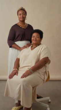 Afro-Amerikan anne ve kızının kamera önünde birlikte poz verişlerinin portre çekimi.