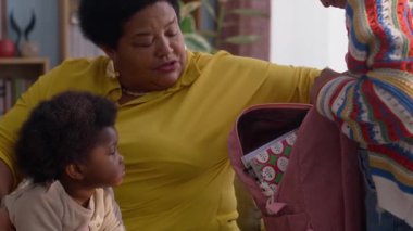 Afrikalı Amerikalı büyükannesini önemseyen, okuldan önce torununun sırt çantasını kontrol eden, küçük kız kardeşine evde bakan