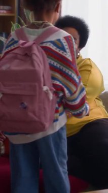 Küçük kız kardeşini kucağında tutarken torununa sarılıp öptüğü dikey fotoğraf.