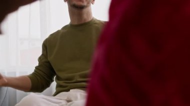 Yavaş çekimde gülümseyen beyaz erkek tekerlekli sandalye kullanıcısı Afrikalı Amerikalı bayan arkadaşına sarılıyor. Uzun zaman sonra onu evinde ziyaret ediyor ve konuşuyor.