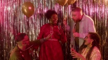 Tekerlekli sandalyeli, neşeli arkadaşlarıyla şampanya tokuşturan, dans eden ve doğum günü partisinde eğlenen genç beyaz çiftin yavaş çekimini kaldır.