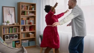 Genç mutlu siyahi kadının, rahat modern oturma odasında genç beyaz erkek arkadaşını selamlarken, sıcak duygusal kucaklaşmalar ve muhabbetler başlatırken, el kamerasıyla çekilmiş bir fotoğrafı.