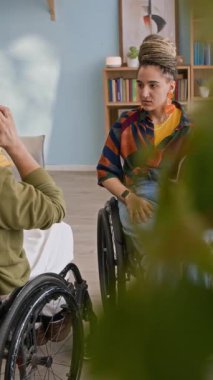 Kafkasyalı engelli genç bir adamın önünde tekerlekli sandalyede oturan ve evinde birlikte vakit geçiren kadın arkadaşıyla sohbete girmesi.