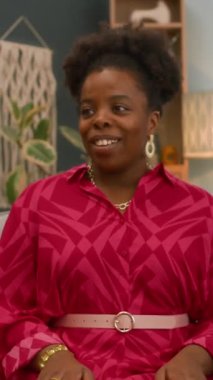 Doğumgününde arkadaşlarının pastayı mumla uzatıp doğum gününü birlikte kutlarken çekilmiş dikey ve yavaş çekimde siyah bir kadın.