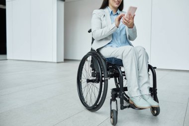 Tekerlekli sandalyedeki gülümseyen iş kadınının küçük ofis içinde dijital tablet kullanarak portresi, kopyalama alanı