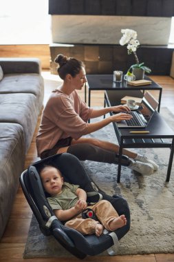 Engelli modern annenin yüksek açılı portresi ön planda sevimli bir çocukla evden çalışıyor, boşluğu kopyalıyor.