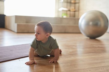 Ön manzara, ahşap zeminde sürünen bebek portresi, fotokopi alanı.