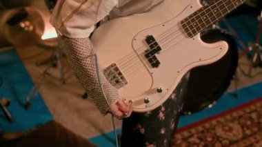 Beyaz elektro gitarı amplifikatöre bağlayan, müzik stüdyosundaki performansa hazırlanan, tanınmayan kişinin yakın plan çekimi.