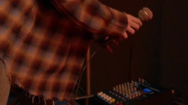 Aptal kızıl saçlı, piercingli, grunge kıyafetli, mikrofonu hazırlayan, müzik stüdyosunda provaya hazırlanan kız.