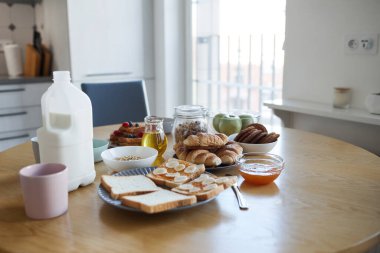 Ev yapımı basit kahvaltı görüntüleri. Süt ve sandviçler ahşap masada. Mutfak iç tarafında.