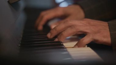Canlı caz performansı sırasında loş, samimi ortamlarda tuşların üzerinden akmakta olan tanınamayan piyanistlerin yakın çekimi