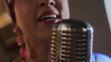 Yumuşak, sıcak sahne aydınlatmasında duygusal performans sunan caz şarkıcısı etkileyici dudaklar ve klasik mikrofon.