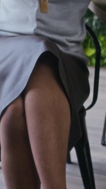 Kendine güvenen Afro-Amerikalı genç iş kadınının dikey portresi başını çeviriyor ve modern yeşil ofiste kameraya ayarlı gözlükler için poz veriyor.