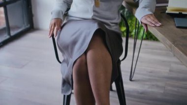 Zarif, genç, kendine güvenen Afro-Amerikan iş kadınının portresi modern yeşil ofiste pencereye bakıyor sonra da kameraya poz veriyor gözlükleri ayarlıyor ve gülümsüyor.