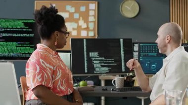 Modern açık uzay ofisinde yeni yazılımlar üzerinde çalışırken çeşitli erkek ve kadın programcıların konuştuğu orta ölçekli görüntüler.