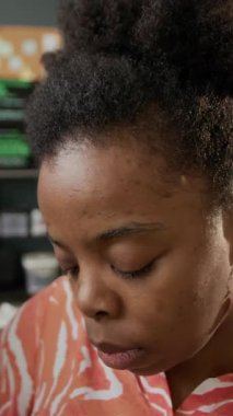 Modern ofiste bilgisayar üzerinde çalışırken ekrana bakan konsantre genç siyahi kadın bilişim uzmanının dikey POV görüntüsü