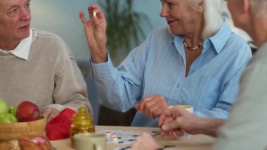 Kafkasyalı yaşlı kadın tombala numarasını mutlulukla açıklayıp yakınlardaki bir adama veriyor. Meyve, abur cubur ve kırmızı jeton çantasıyla birlikte masada oynuyorlar.