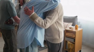 Genç Afrikalı Amerikalı kadın terapist ve üç Kafkasyalı son sınıf öğrencisinin grup terapisi sırasında birbirlerine sıcak bir şekilde sarıldıkları yavaş çekim.