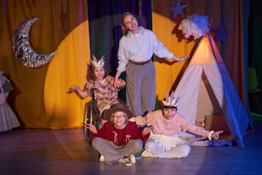 Drama okulunun bayan yönetmeninin müzikal oyundan sonra kostümlü genç aktörlerle son yayını yaparken, gelişim engelli çocuklar için kapsamlı bir tiyatroda sahnelendi.