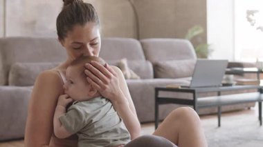 Bacak protezi takmış bir kadın dizlerinin üstüne çöküp onu öperken ve kucaklarken orta boy bir fotoğraf.