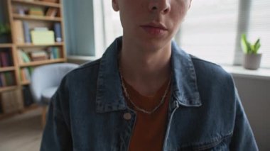 Düşüncelere dalmış, kafkasyalı bir gencin açık modern sınıftaki danışmanlık sırasında sandalyede oturan renkli kartları tutarken çekilen görüntüsü.