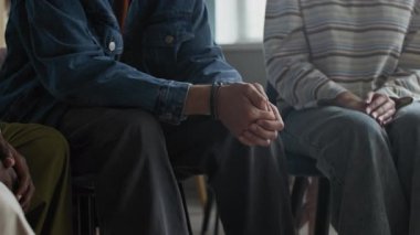 Sınıfta grup terapisi sırasında kendisini destekleyen empatik akranlarına sorunlarından bahseden savunmasız beyaz bir gencin el kamerasıyla çekilmiş görüntüsü.