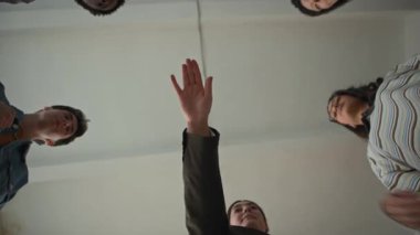 Çeşitli gençlerin el ele tutuşup havaya kaldırarak birlik, destek ve işbirliği hissi yarattıkları genç bayan öğretmenlerin görüntüsü altında.