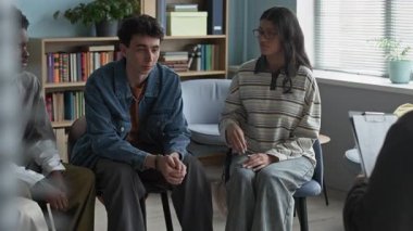 Hayal kırıklığına uğramış Kafkas ergen çocuk sınıfın etrafında toplanmış, grup terapisi sırasında onu destekleyen, ön planda tanınmayan bir okul danışmanıyla birlikte.