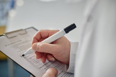 Tanımlanamayan tıp fakültesi profesörünün yan görünümü panoya yazı yazması ve sınıfta devamlılığı kontrol etmesi, kopyalama alanı