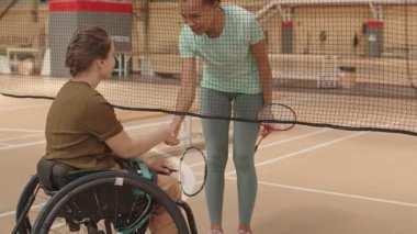 15 yaşında, tekerlekli sandalyede beyaz bir kıza doğru yürüyen ve rakipleri kapalı sahada el sıkışan, elinde badminton raketleri olan çok ırklı kadın sporcu kitlenmişti.